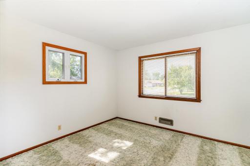 The primary bedroom has windows facing the back and side yard and has a good sized closet with a light.