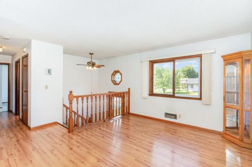 The spacious living room welcomes you to the upper level with pergo laminate flooring. The seller says there's hardwood floors under all of the floors on the upper level with exception of the kitchen and bath.