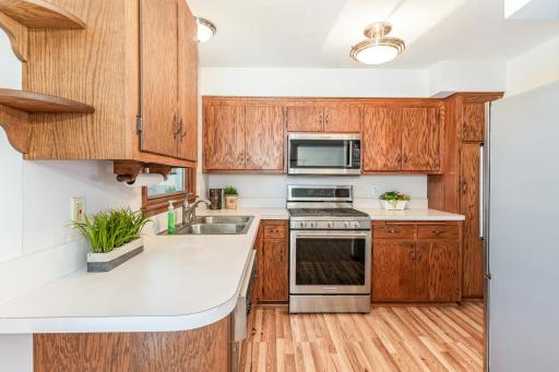 The kitchen has stainless steel appliances, a sink over the window with views of the backyard and a pantry.
