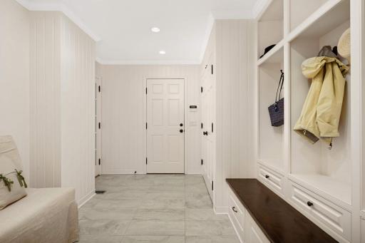 The mudroom is quite spacious with a double closet, three cubbies, and doors to both the backyard and the heated finished double garage with epoxy floor and two drains.