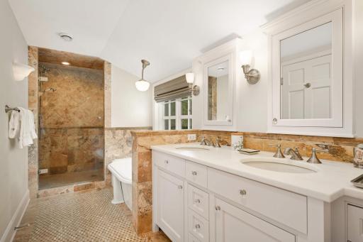 The primary bath features a double vanity, a jetted tub, a spacious separate shower with two heads, a heated floor, and a separate water closet