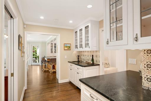 A convenient wet bar area has soapstone countertops, a Sub-Zero beverage refrigerator, and wonderful storage, making it perfect for entertaining.