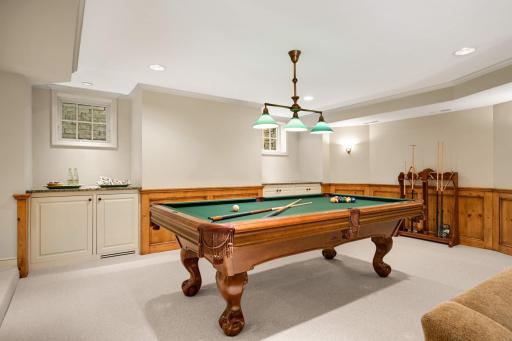 The step down Billiard area features paneled wainscoting, 2 windows and a beverage refrigerator
