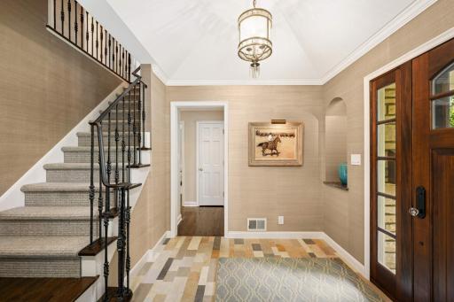 The welcoming foyer with French limestone flooring and a tray vault accent ceiling