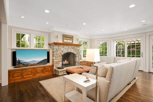 The family roomâs focal point is an arched stone fireplace flanked by built ins. A bayed wall of windows and a sliding door flow out to the patio