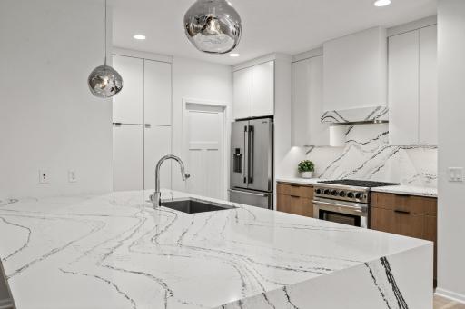 This stunning modern kitchen features an entertainer’s dream island with a dramatic waterfall-edge quartz countertop, sleek finishes, and ample space for hosting. $260k Ispiri Professional Remodel!