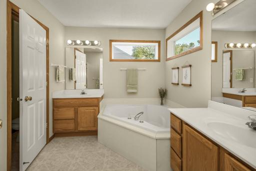 Primary bath with double vanities and a deep soaking tub.