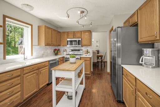 Spacious kitchen quartz countertops, tile backsplash-2022. Window looks out over backyard.