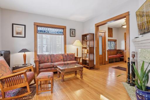 Inviting living room has ample natural light, wood floors, new ceiling, and tile fireplace