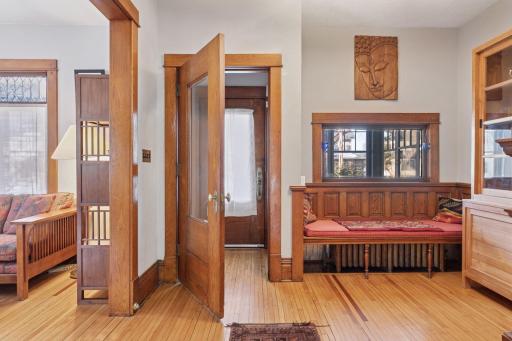 Foyer features original woodwork, doors and built-in bench