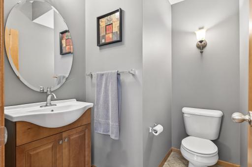 The lovely guest bathroom on the main level is much larger than your typically half bathroom and features a neutral gray paint color and a maple vanity.