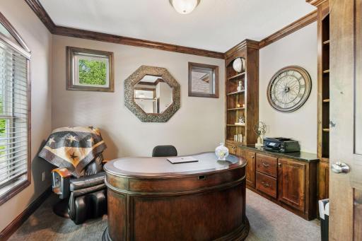 Private main floor office with custom built-ins and crown molding