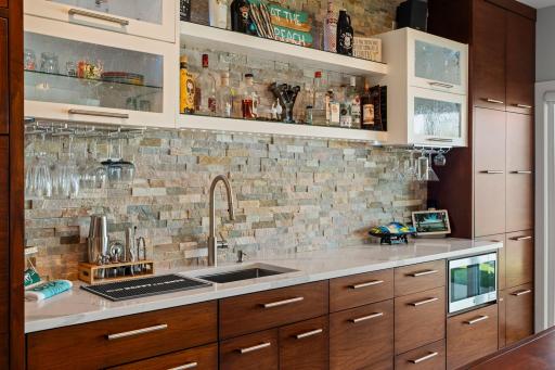 A beautiful stone backsplash paired with sleek countertops creates a striking design statement