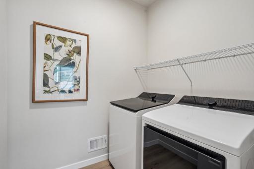 Convenient main level laundry room with side-by-side washer and dryer, designed for easy access and everyday efficiency.