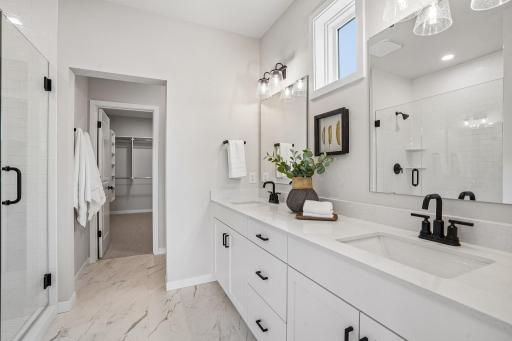 Primary bath showcases a dual-sink vanity complemented by modern black hardware.