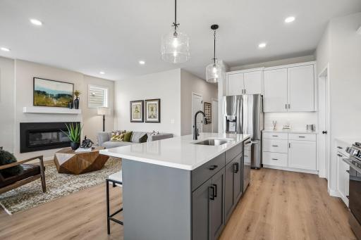 Kitchen showcases 42" white upper cabinets, and elegant pendant lighting over the island and great conversation to the gathering room!