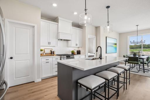 Quartz countertops and tile backsplash add a modern, refined touch to the kitchen.