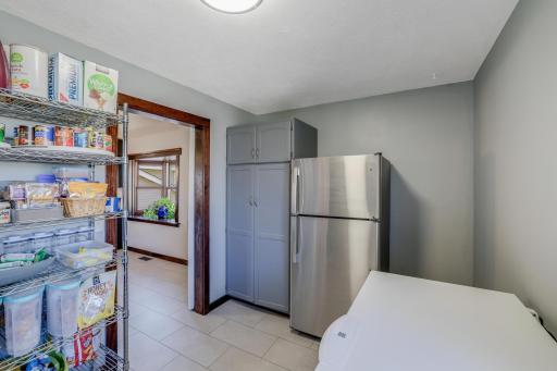 It is located right off the kitchen area with a fridge, microwave, counter space, cabinets and space for a chest freezer. It is the perfect space to prep holiday meals or for those overflow crockpots.