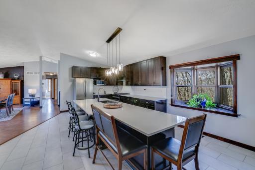 The main level features a sprawling open-concept kitchen and dining area, complete with stainless steel appliances, a sizable island with a breakfast bar, an epic amount of storage, and an additional pantry space that can be used for extra storage.