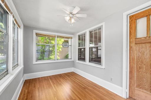 Enclosed front porch with hardwood floors that are in amazing condition