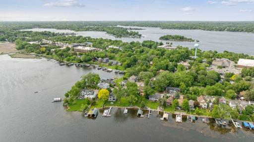 A stunning aerial view of Spring Park showcases its charming lakeside setting, with multiple bays of Lake Minnetonka unfolding in the backgroundâhighlighting the area's natural beauty and vibrant waterfront lifestyle.