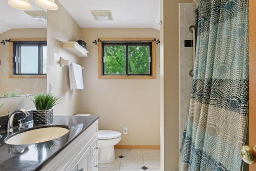 Beautifully appointed full upper-level bath featuring tiled floors, a granite vanity, and a classic large tubâblending style and functionality.