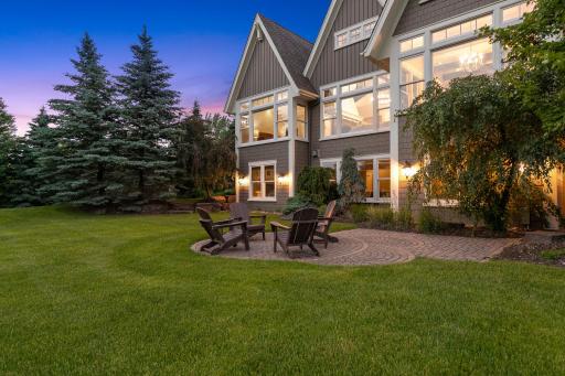 Custom, paver patio with interlocking circular patio spaces for backyard gatherings. Picturesque landscaping includes several garden areas highlighted with a variety of perennials, trees, shrubs, and gorgeous slate rocks.