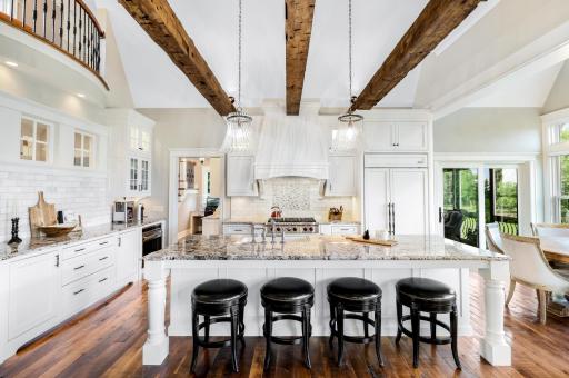 Spacious island with granite countertops, breakfast bar seating, apron sink and pendant lighting coming down from the vaulted ceiling.