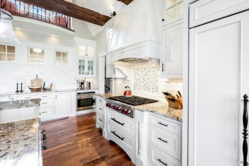 An abundance of granite counter space throughout with subway style backsplash + intricate glass tiled accent over the gas cooktop.