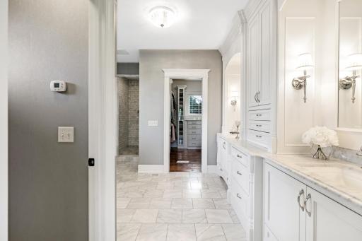 Raised height, enameled vanities with granite countertops and floor-to-ceiling built-ins in between.