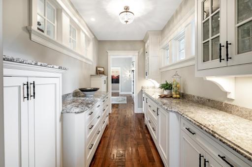 Additional enameled cabinetry with lighted, glass display uppers, plus granite countertops along both sides for additional storage & multi-level serving space.