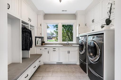 Dual sliding barn-door entry, tile floors and an incredible amount of built-in cabinetry with charming beadboard accents. Custom lockers & cubbies with built-in, padded bench seating. â¢	Large window over the sink and granite counter area for folding