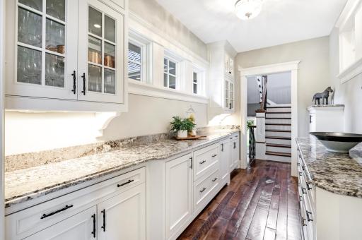 Walk-through access from the foyer to the back hallway/shares a wall with the kitchen. Upper windows on both sides that overlook the front porch & the kitchen.