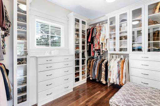Huge walk-in closet is loaded with amazing, custom built-ins, plus is U-shaped with doors connecting to the primary bath and the hallway.