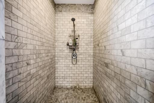 Spacious open area includes a freestanding soaking tub and large, walk-in, tile shower.
