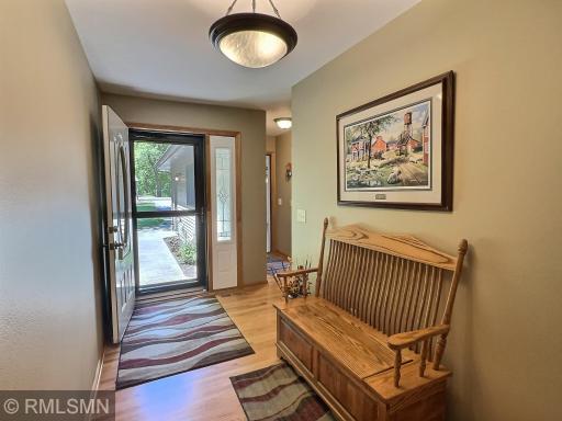 Step into a warm and welcoming foyer featuring hardwood floors and soft natural light, there's plenty of space for a bench or seasonal decor.