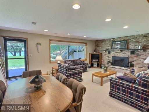 A wall of windows fills the space with natural light, while a charming brick fireplace adds warmth and character - perfect for entertaining.