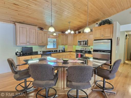 The heart of the home features a beautifully designed kitchen with custom wood cabinetry, granite countertops, and a spacious center island with seating.