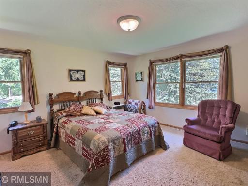 Wake up to serene lakeside views of Sugar Lake from the comfort of this spacious primary bedroom, a peaceful and private haven.