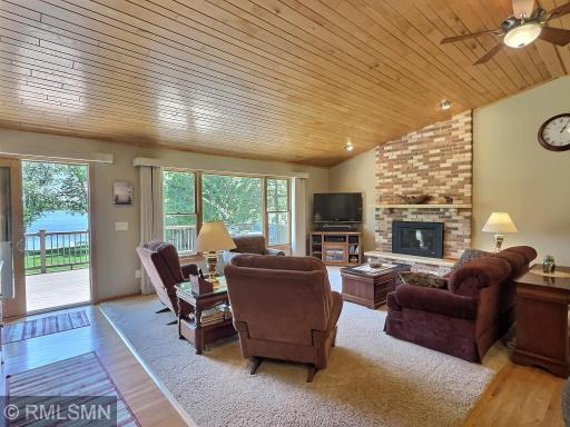 Gather in the spacious lakeside living room, where vaulted wood ceilings and a wall of windows frame breathtaking views of the water.
