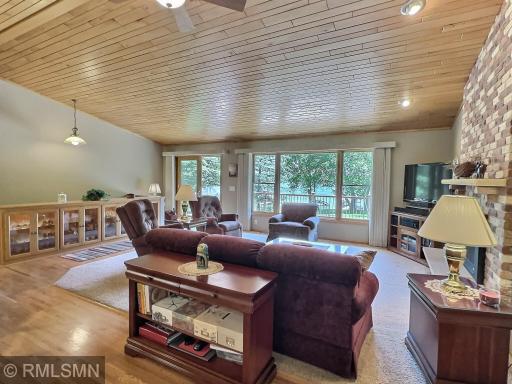 A cozy gas fireplace with a striking brick surround anchors the space, while natural light fills the room, creating a warm and inviting atmosphere.