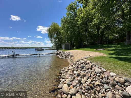 Fantastic shoreline landscaping complete with sandy beach offers the ideal lake day setting.