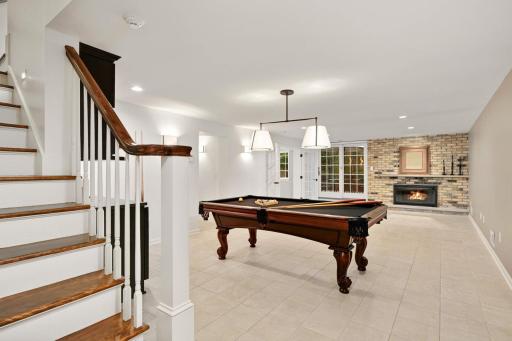 Walkout level's billiards and 2nd family room has a 3rd brick fireplace and slider to a brick patio