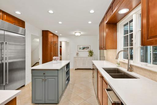 There is a quartz countertops and a herringbone marble backsplash