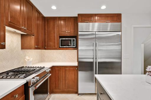 A 48" Sub Zero SS refrigerator and a Kitchen Aide SS gas range
