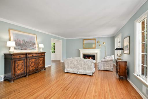 The tremendous living room and pretty woodburning fireplace and traditional mantel and crown molding.