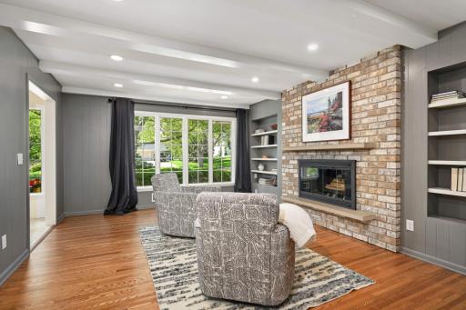 The large main floor family room features a brick wood burning fireplace flanked by bookcases