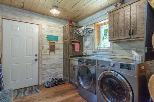 Main level laundry with wash sinks and custom cabinets
