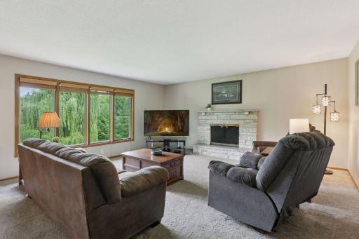 A wall of windows streams natural light into the living room on the main floor. A stacked stone wood burning fireplace anchors this space.