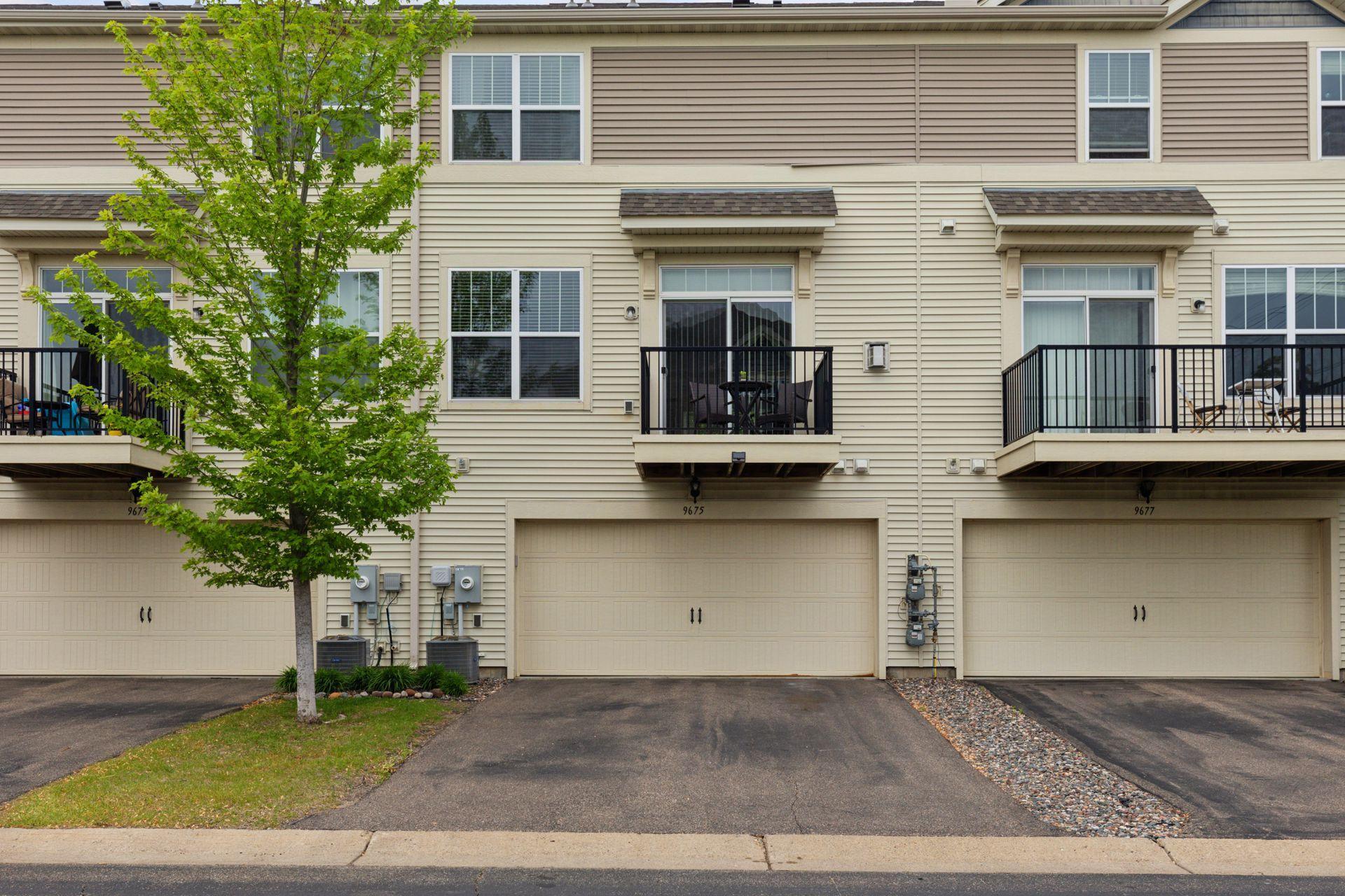 Back of townhome looking at deck and 2 car attached garage.